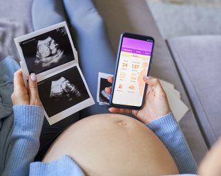embarazada mira una app de control y unas ecografias